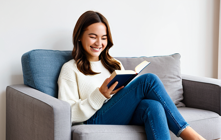 **

"A woman in her late 20s, fully clothed in a modest, casual outfit (jeans and a sweater), sitting comfortably in an armchair in a sunny, minimalist living room. She is smiling gently and holding a physical book. In the background, a charging station with a phone is visible, but the focus is on the woman and the book. Safe for work, appropriate content, family-friendly, perfect anatomy, correct proportions, well-formed hands, natural pose, professional studio photography, soft lighting, healthy lifestyle aesthetic, uncluttered environment, promoting mindful consumption and relaxation."

**